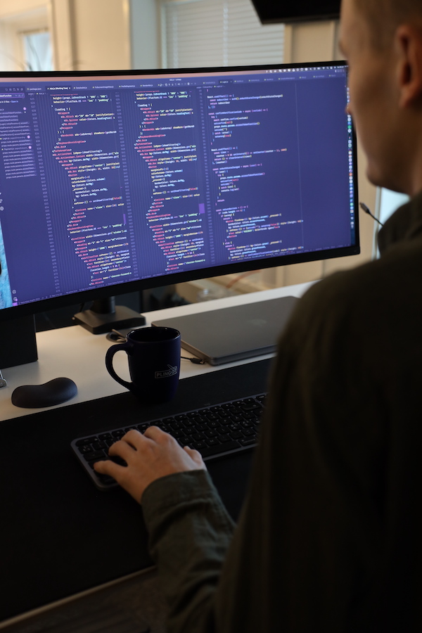 utvecklare sitter och kodar system framför dator